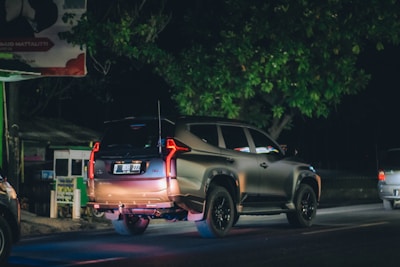 Security patrol vehicle driving through a residential neighborhood at dusk.