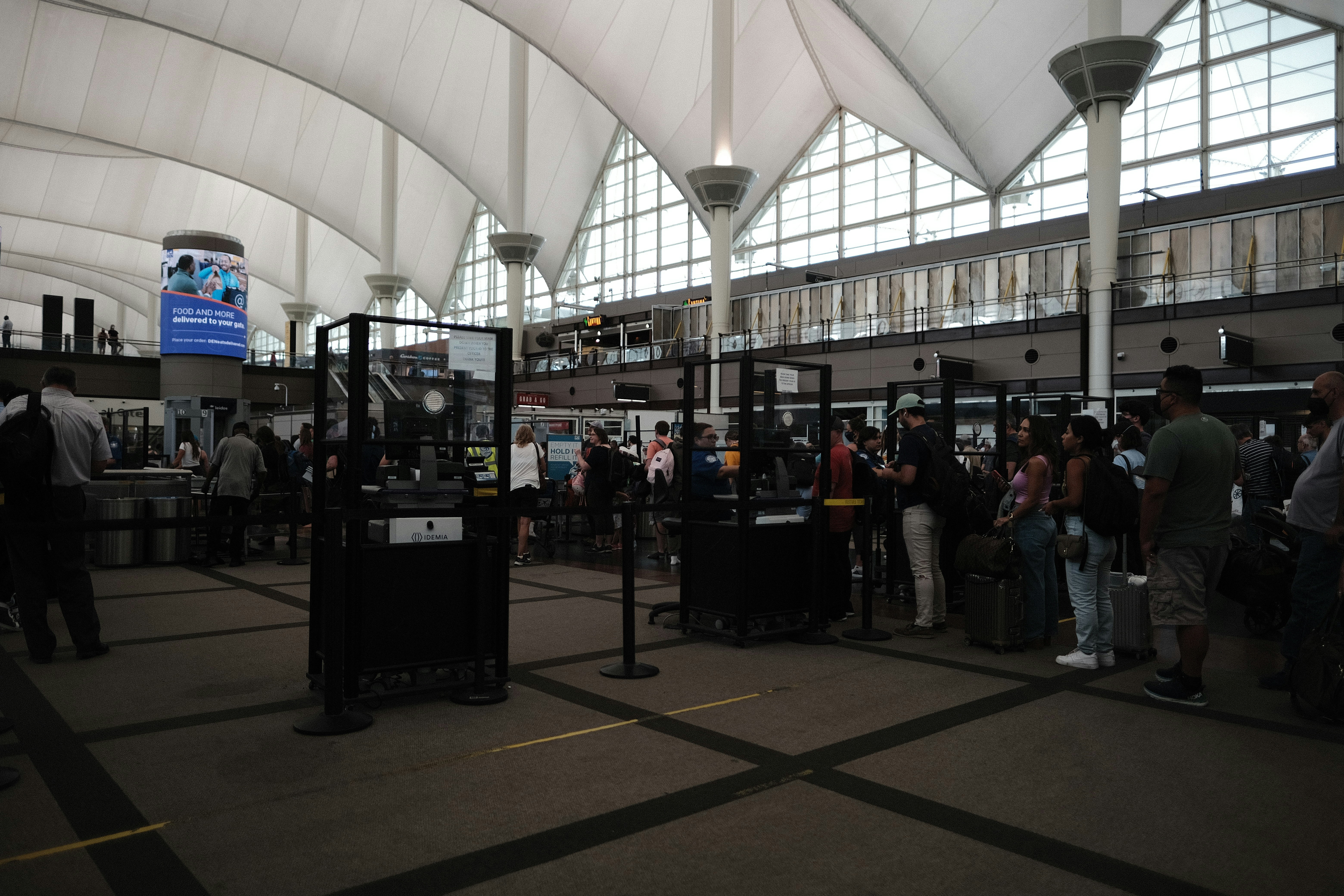 a group of people standing in a large room with a large window