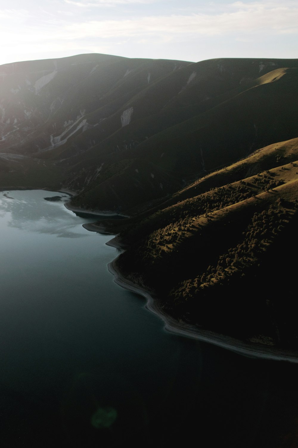 a large mountain with a body of water below