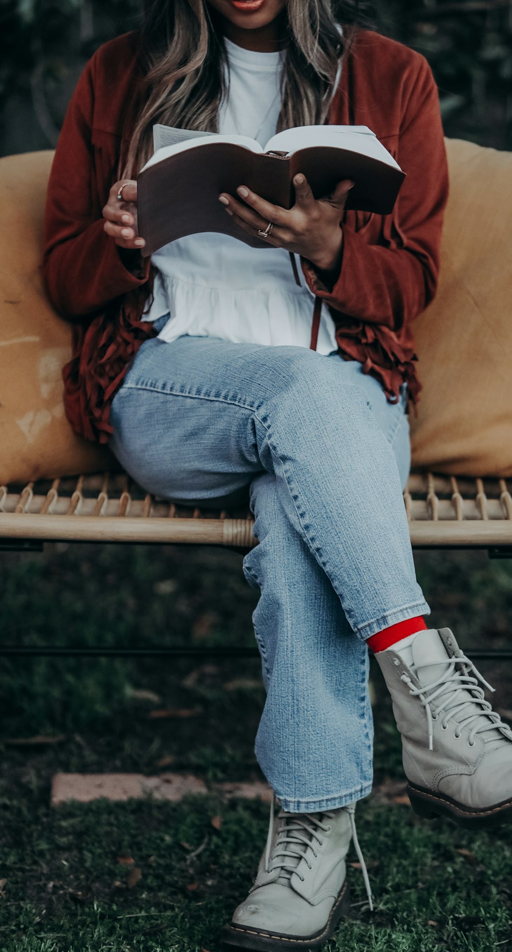 a person sitting on a bench reading a book