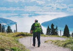 a man with a backpack walking on a trail in the mountains