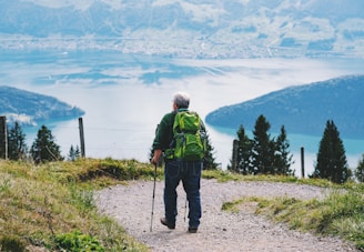 a man with a backpack walking on a trail in the mountains