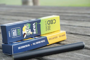 Assorted cannabis vape cartridges arranged neatly on a wooden surface.