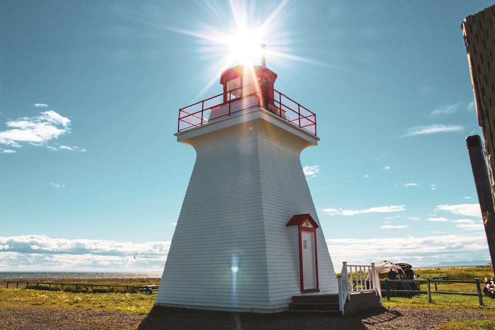 a lighthouse with the sun shining through the clouds