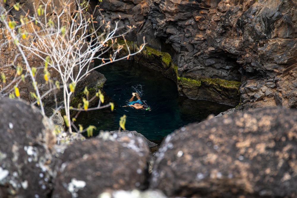 a person swimming in a small pond