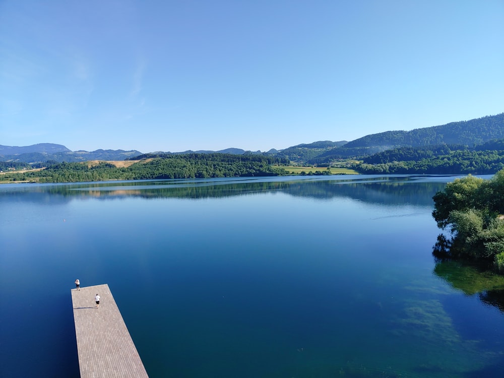 a body of water with trees and hills in the background