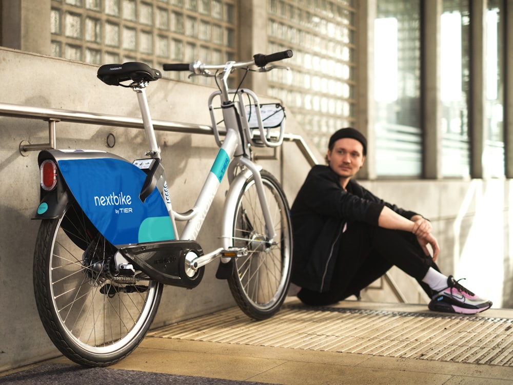 a person sitting next to a bicycle