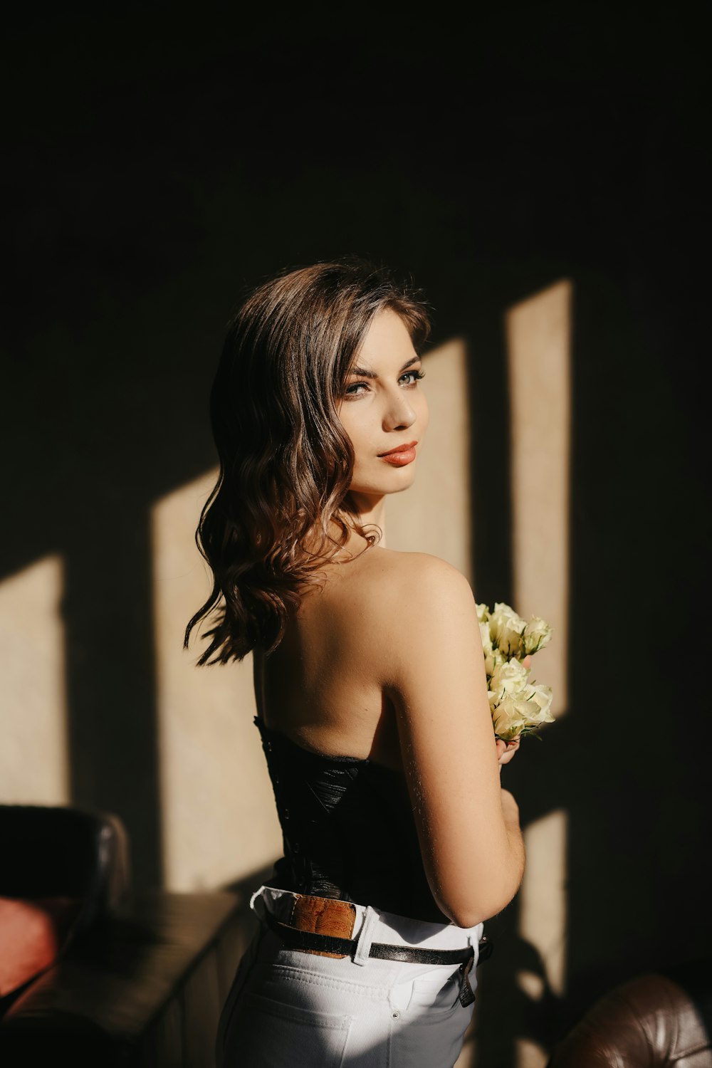 a woman with a black top and a black tank top with flowers in her hair