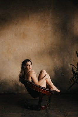 A serene portrait of Claudia Porcher sitting calmly in a warm beige room with soft natural light.