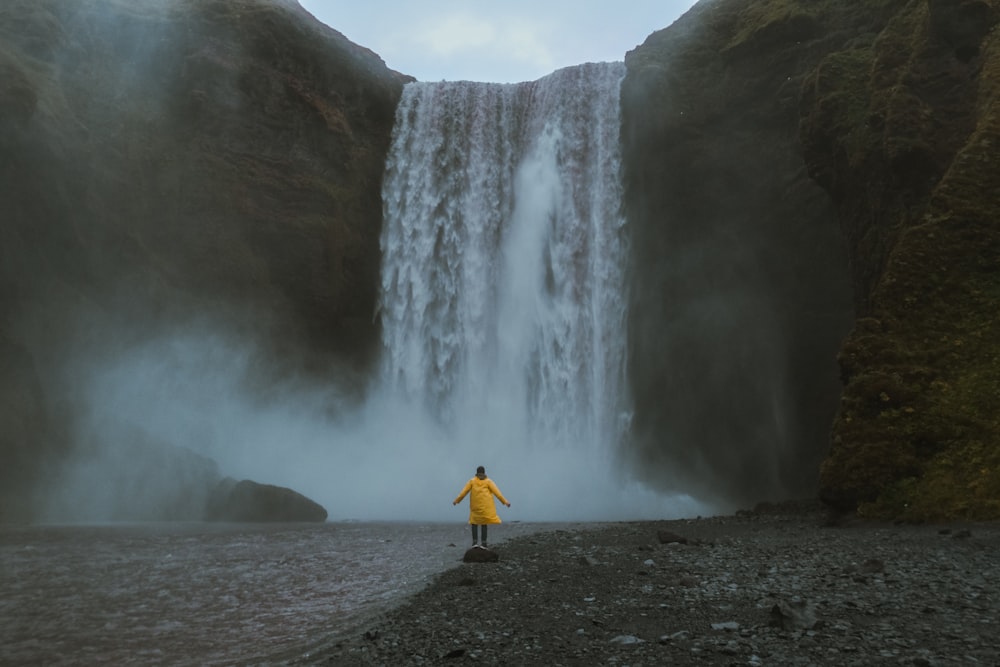 a person standing in front of a waterfall