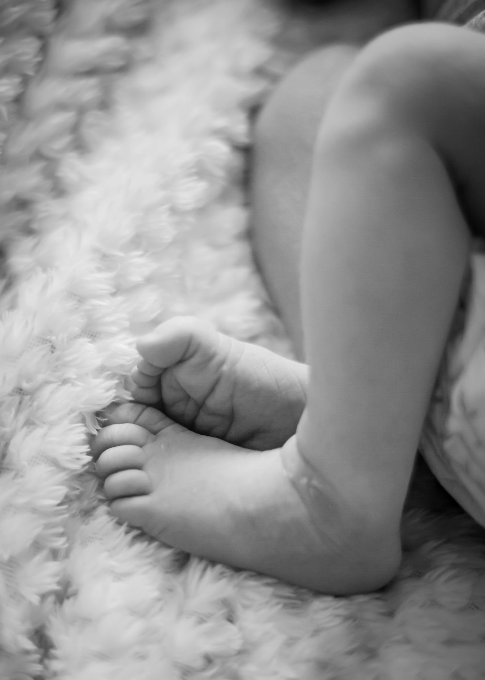 a baby's foot on a blanket