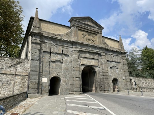 A stone building with a large arched doorway — Bergamo, Italy