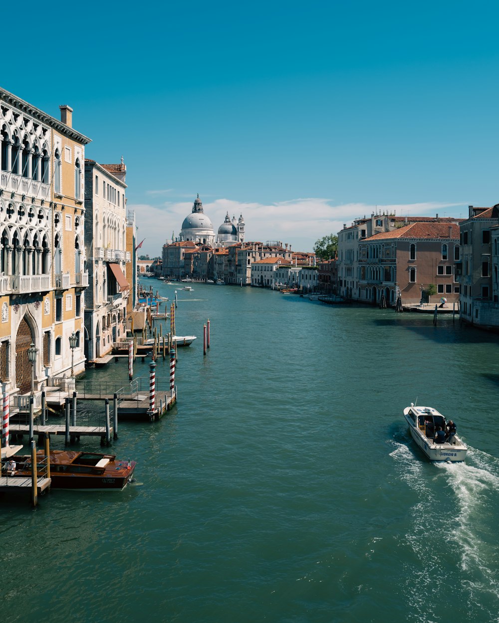 a river with boats in it and buildings along it with Grand Canal in the background