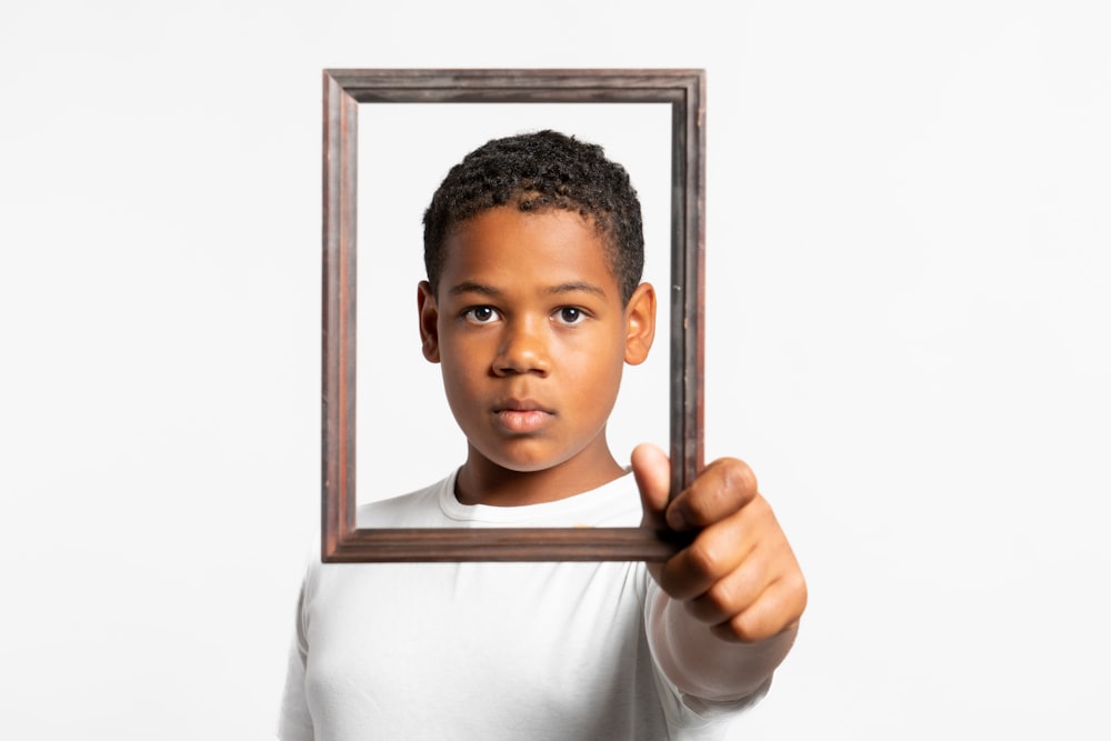 a boy holding a picture frame