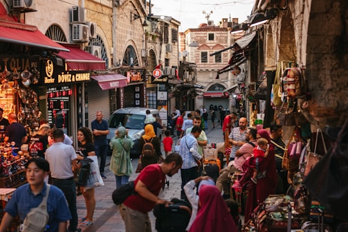 a crowd of people walking through a busy street