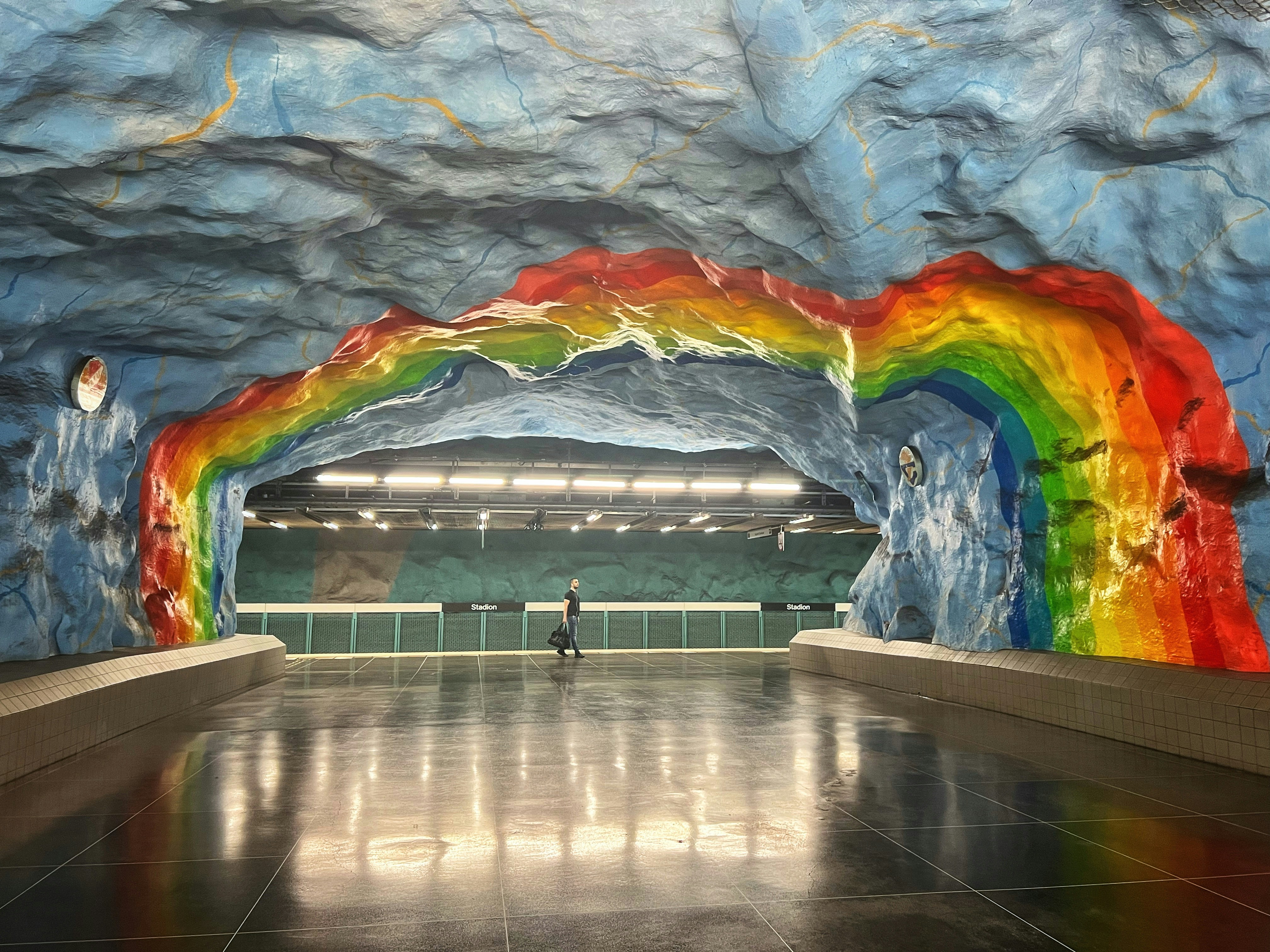 a person standing in a large room with a large mural on the wall