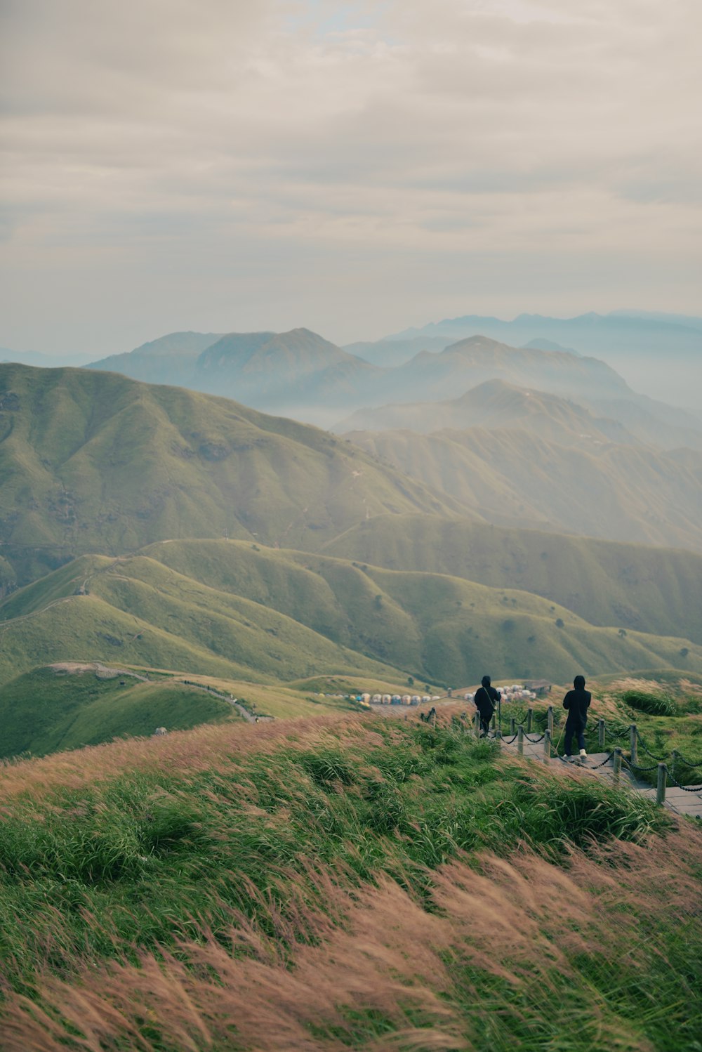 a group of people walking on a trail in a hilly area