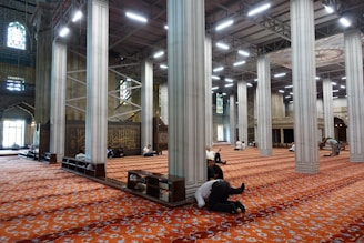 A spacious, clean prayer hall decorated with gentle geometric patterns.