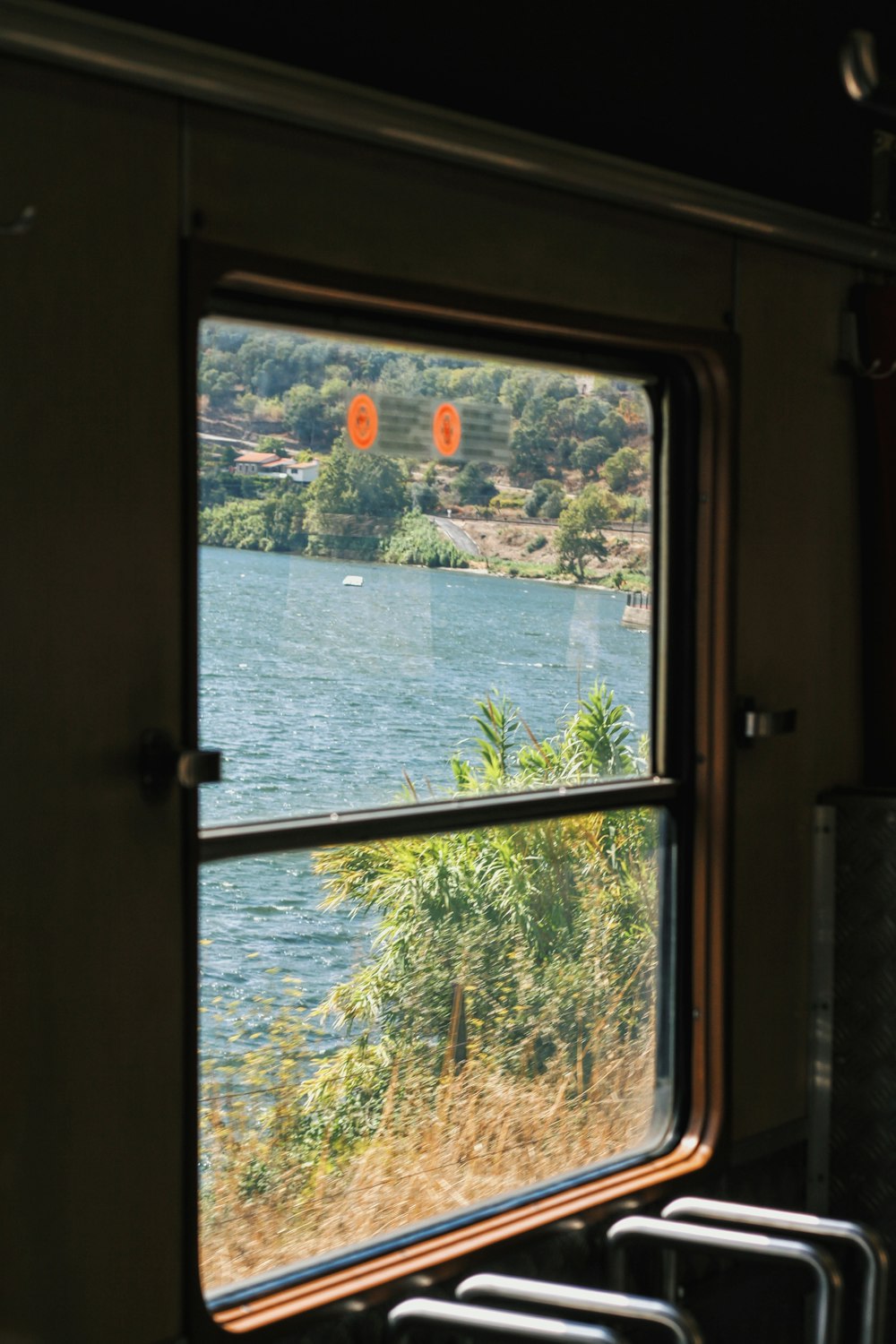 uma janela com vista para um lago e árvores