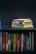 A collection of self-help and motivational books are neatly organized on a black bookshelf. On the top shelf, there is a small stack of books including 'Tuesdays with Morrie', 'The Magic of Thinking Big', 'Think and Grow Rich', and 'The Power of Now'. The bottom shelf displays a variety of books such as 'The Alchemist', 'Freedom from the Known', and 'The 7 Habits of Highly Effective People'. The setup suggests a personal library focused on personal development.