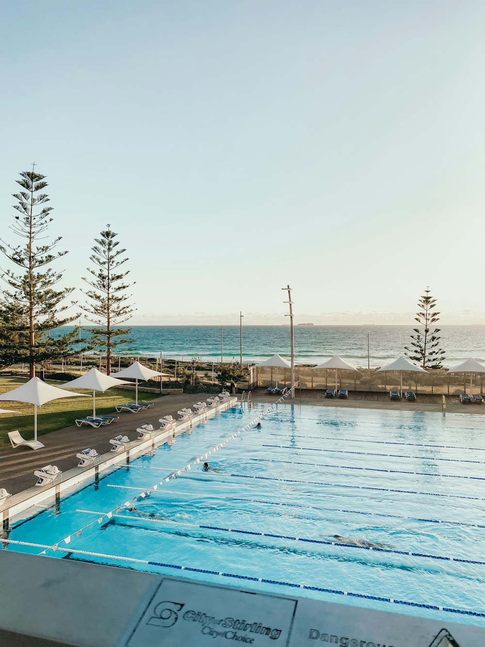 a pool with a beach in the background