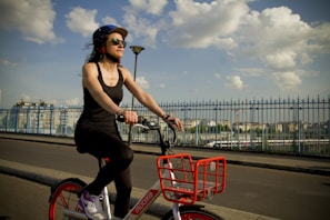 A happy customer riding a rented bicycle on a city street.