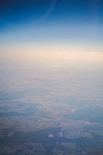 Aerial view of lush green farmland near Bhiwani under clear blue sky.