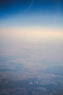 Aerial view of a vast green farm with clear blue sky.