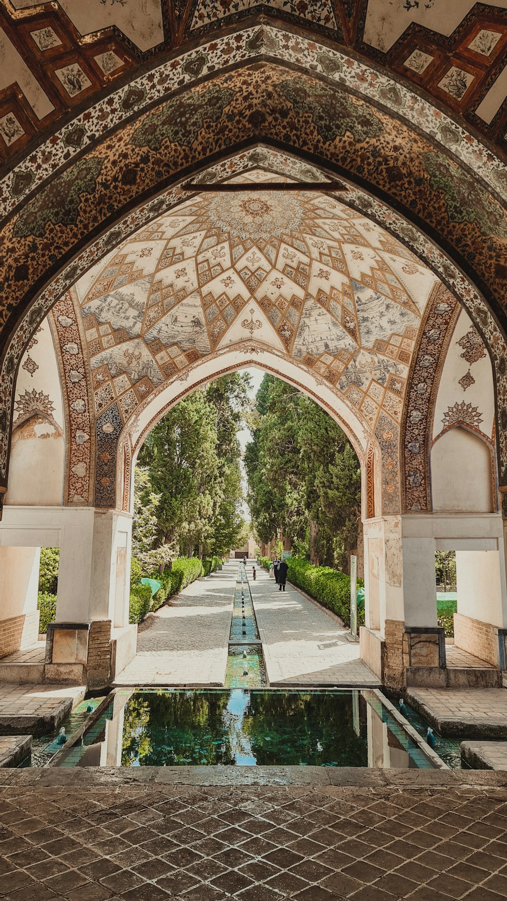 a courtyard with a pool and a large arched doorway