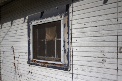 Detail of a repaired wooden window frame with fresh paint blending seamlessly.