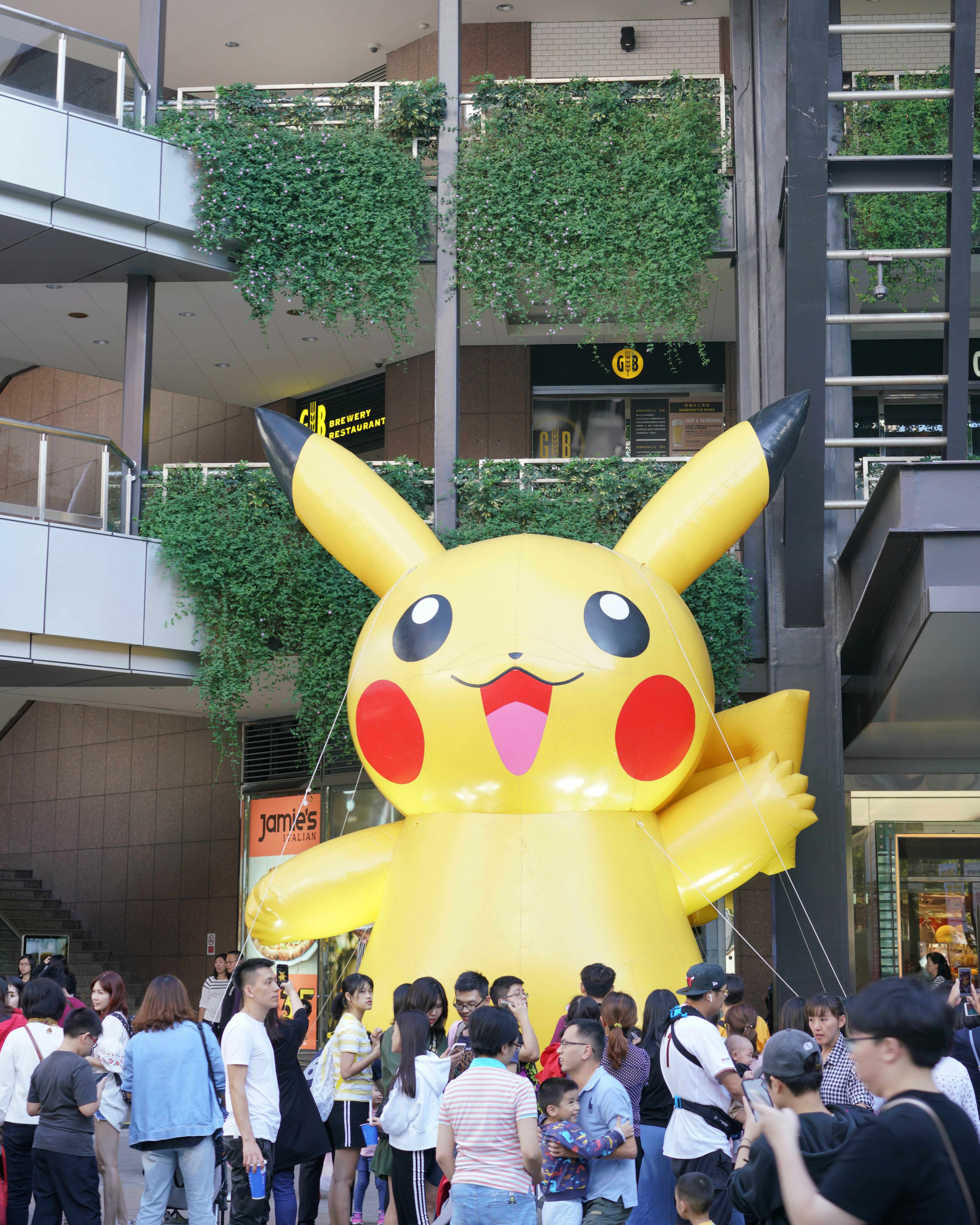 a large yellow balloon in front of a crowd of people
