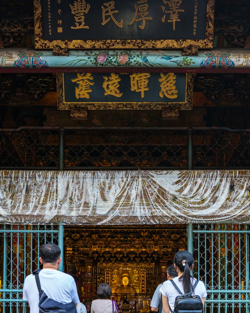 people walking past a gate