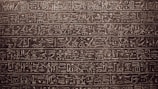 An artistic representation of hieroglyphic writing on a stone tablet.