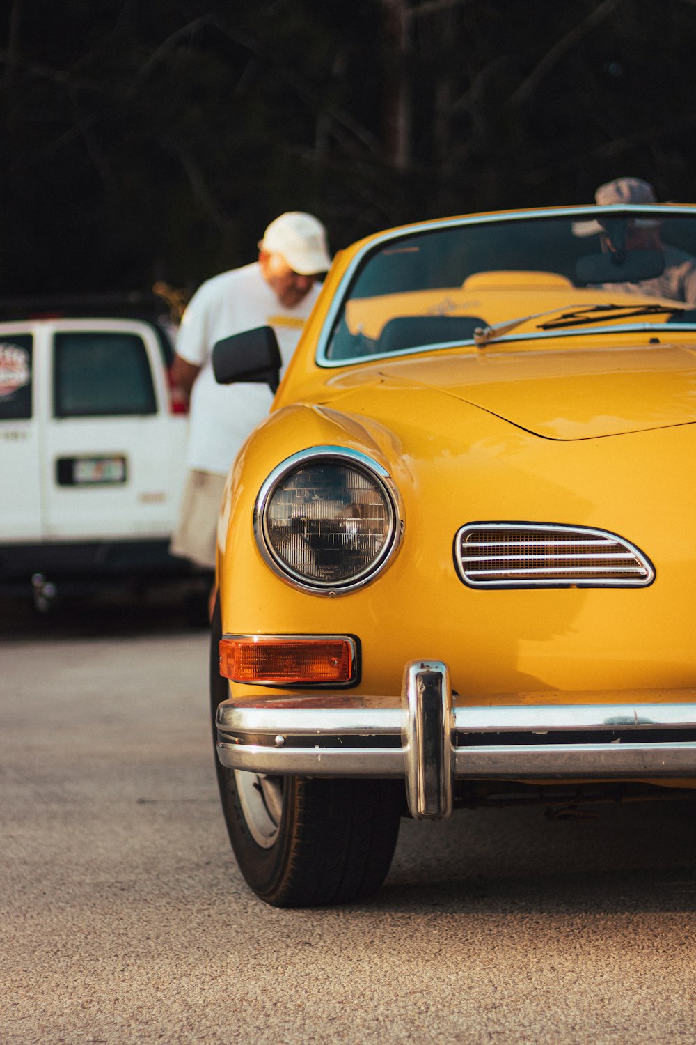 a person standing next to a yellow car