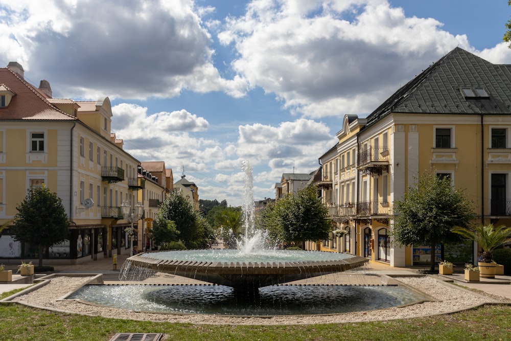 a fountain in a courtyard between buildings