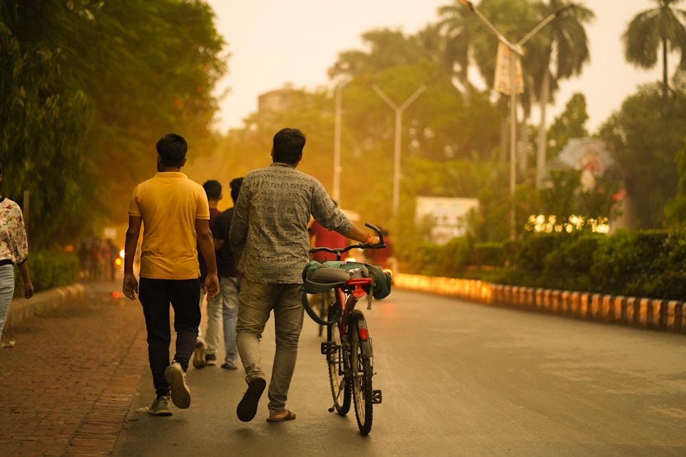 a group of people walking down a street with a bicycle