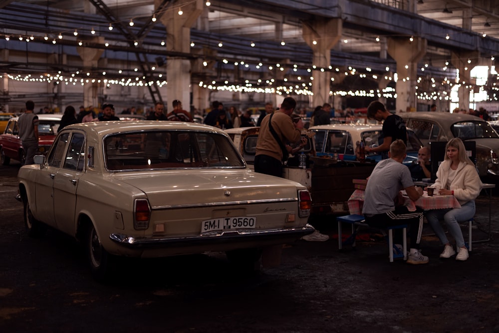 a group of people sitting around a car