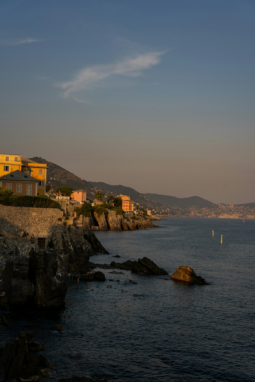 a body of water with rocks and buildings along it