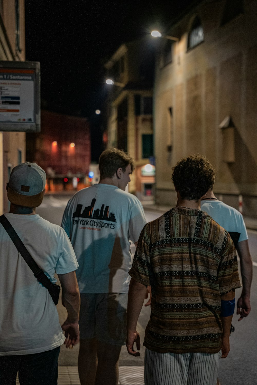 a group of people walking down a street at night