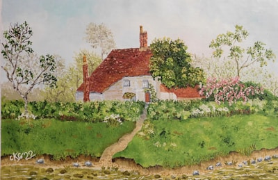 A cozy cottage with a warm red tile roof surrounded by greenery