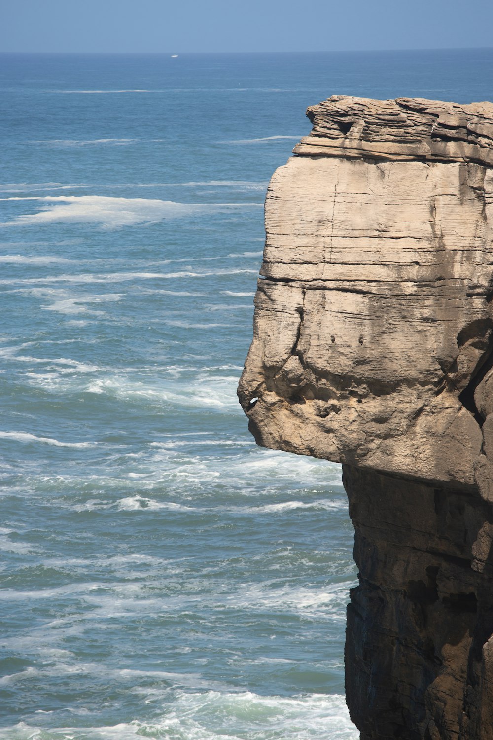 a cliff with a body of water below