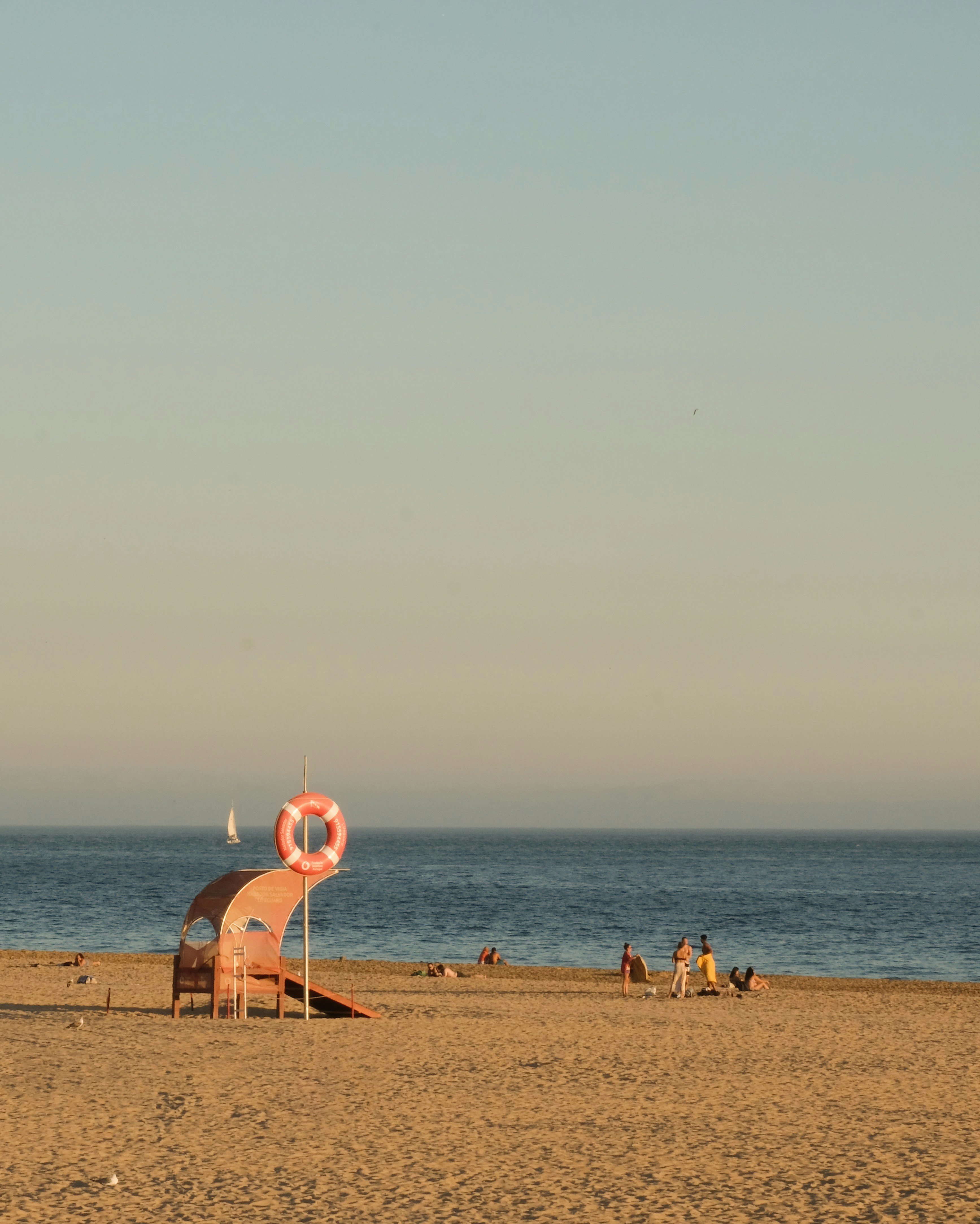 a beach with a structure and a body of water in the background
