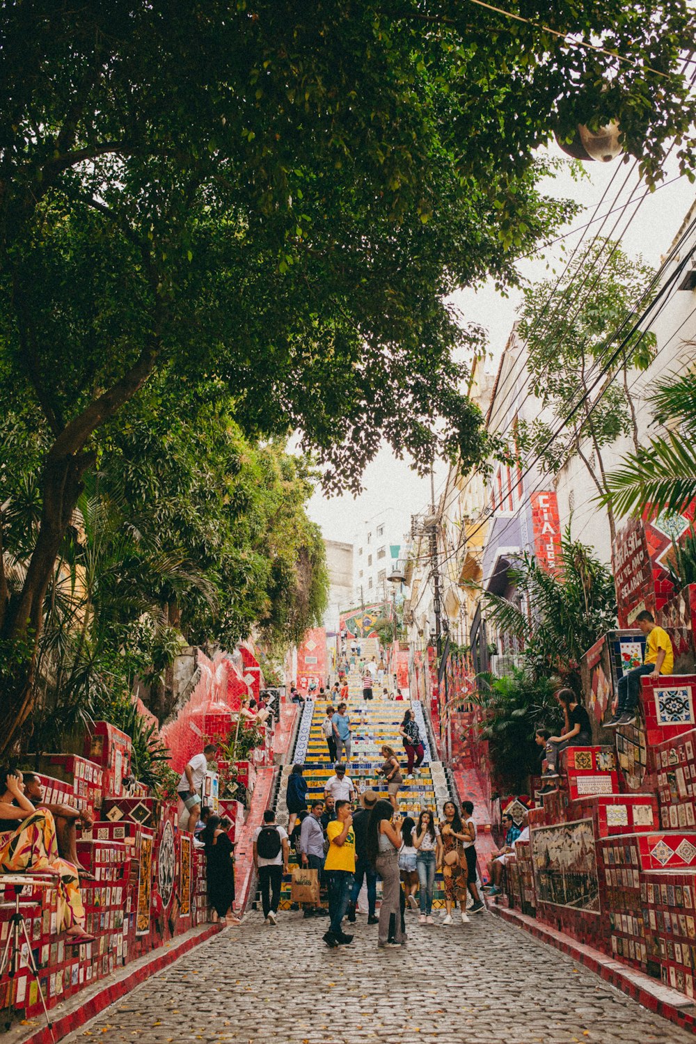 a group of people walking down a street lined with shops