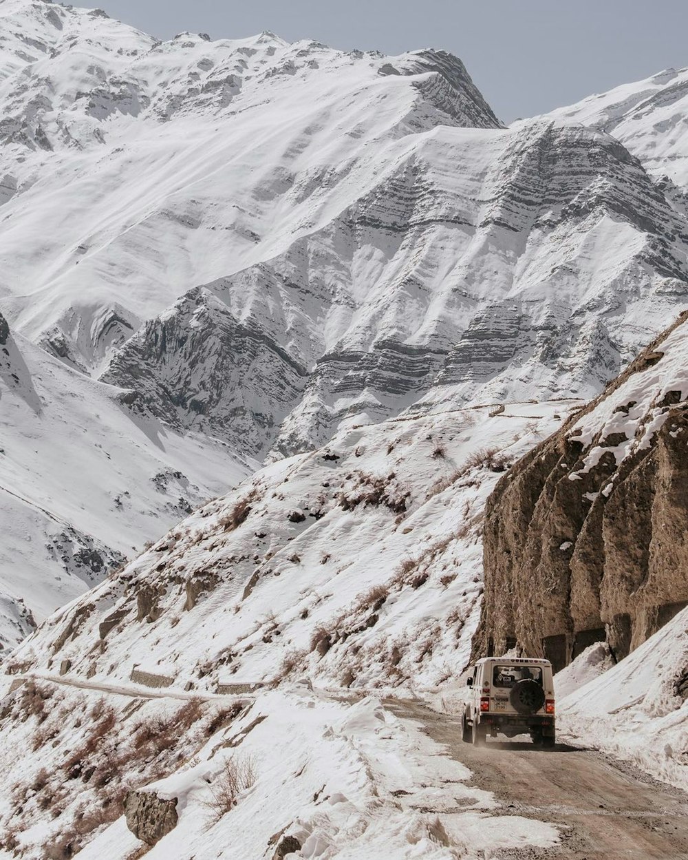 a truck driving on a snowy mountain