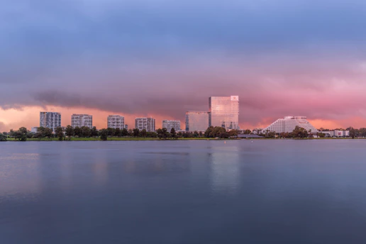 A serene city skyline at dusk with warm earth tones reflecting off the buildings.
