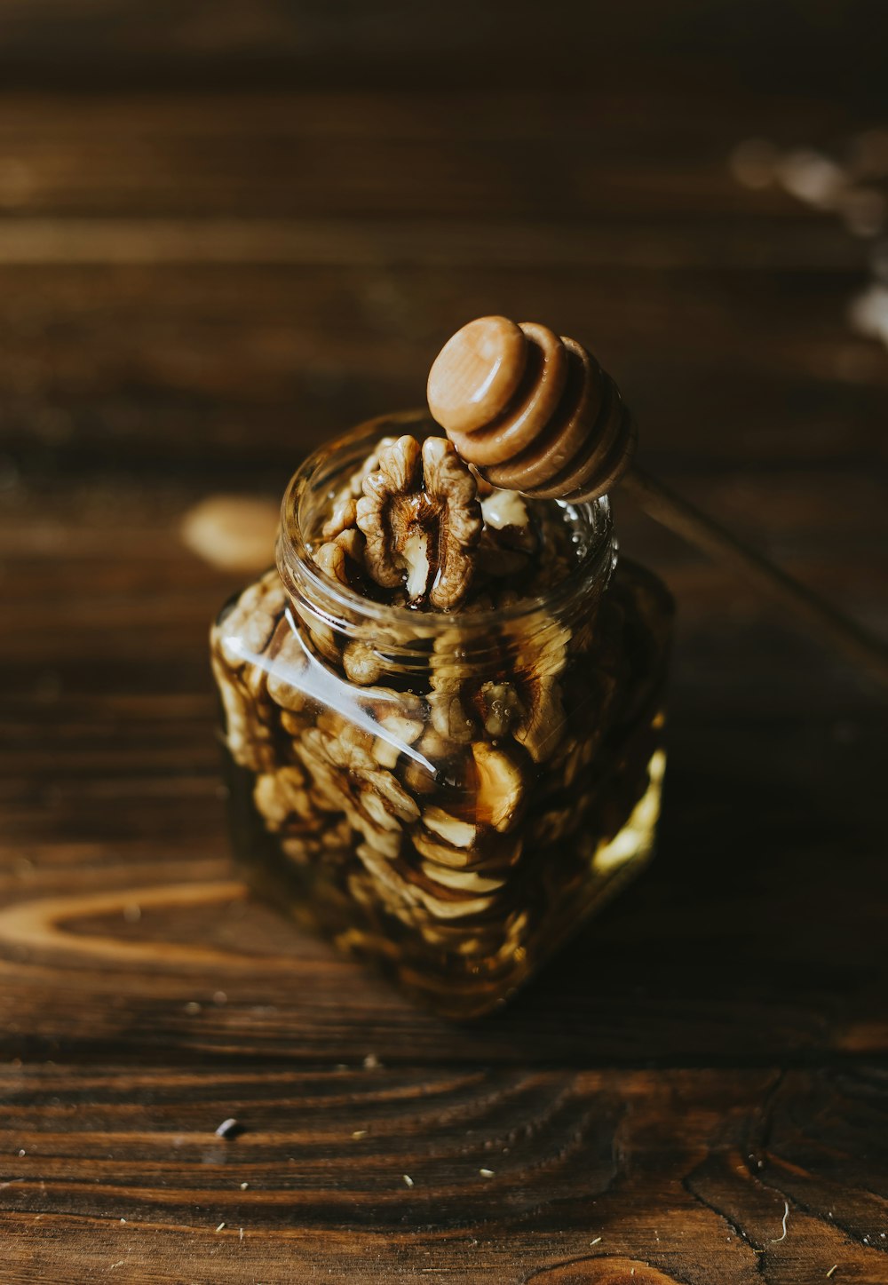a jar with a lid and a handle on a wood surface