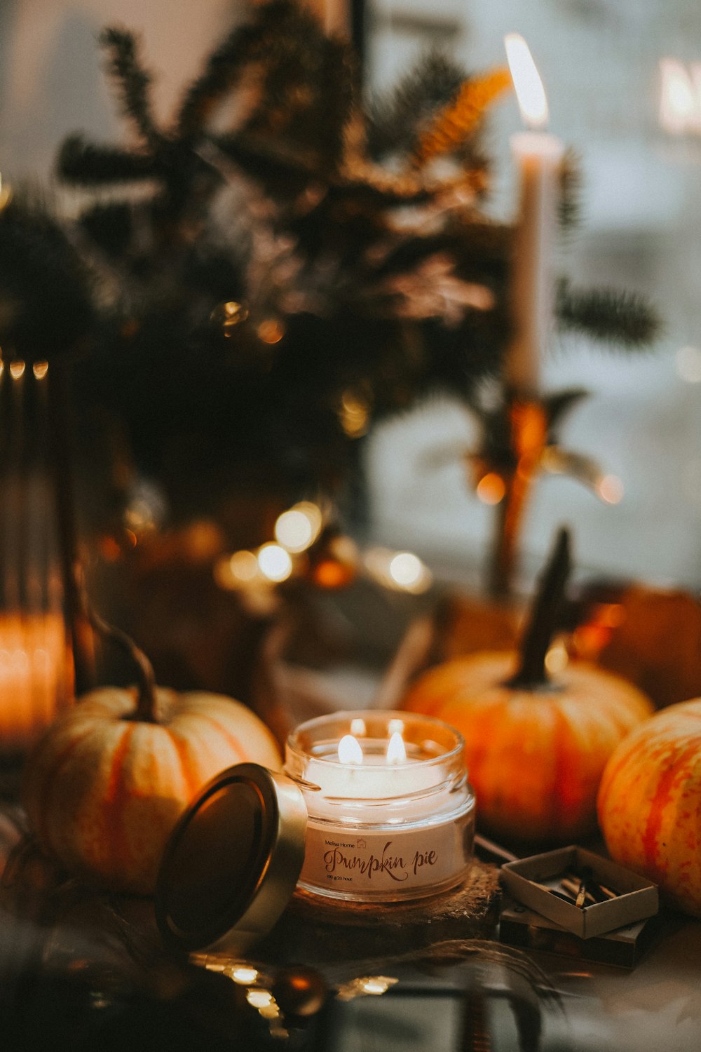 a candle next to a glass jar with a candle in it