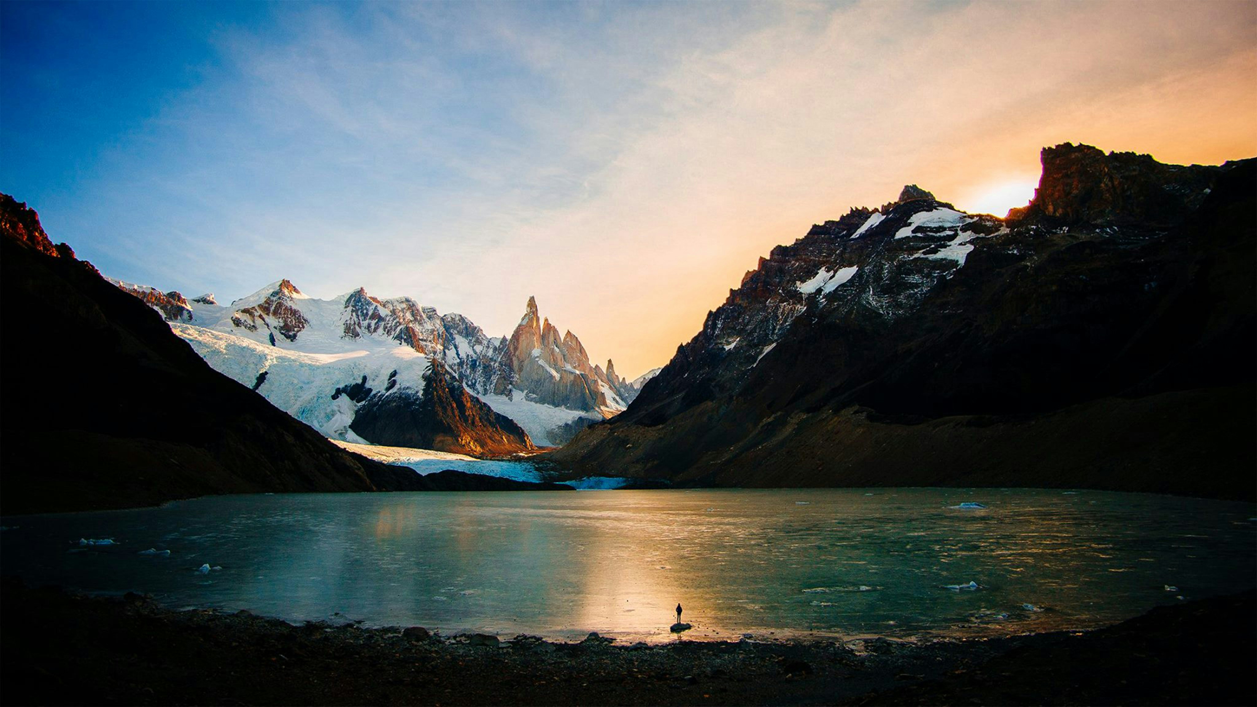 a body of water with mountains in the back