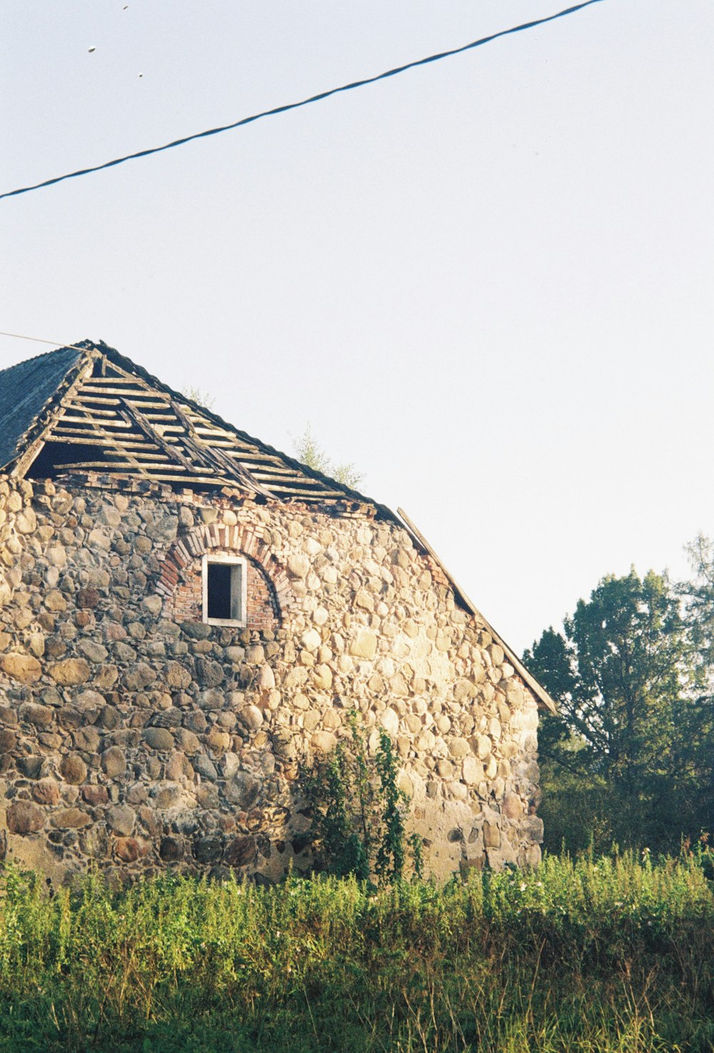 a stone building with a grass field