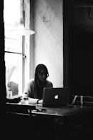 a person sitting at a table with a laptop